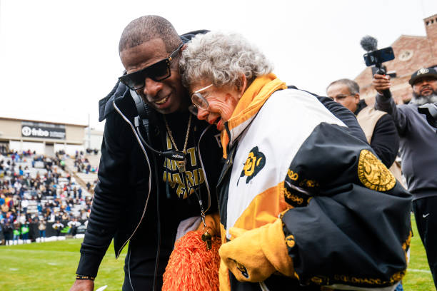 Deion Sanders, left, hugs 98-year-old fan Peggy Coppom, who Sanders invited to be part of the pre-game ceremonies to kick off the Spring football game as part of Black and Gold Day on April 22, 2023. (Photo by Michael Ciaglo for The Washington Post via Getty Images)